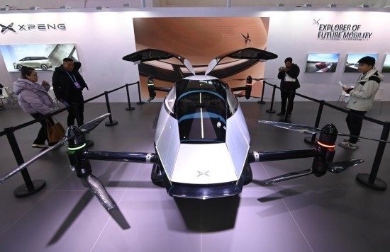 2023年12月1日，在鏈博會智能汽車鏈展區(qū)小鵬汽車展臺，參觀者觀看一臺智能飛行器。新華社記者蔡湘鑫攝