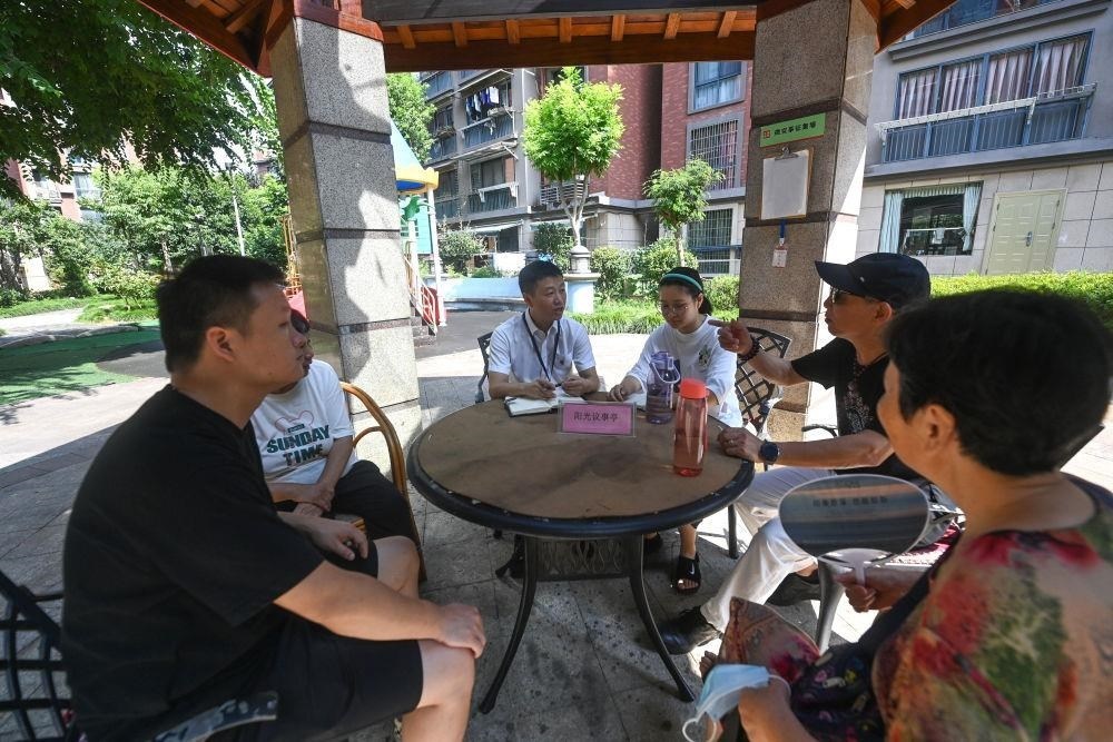 △2023年7月21日，在位于浙江杭州臨安區(qū)錦南街道水岸陽光小區(qū)的陽光議事廳，街道干部在聽取居民們反映的問題及意見。
