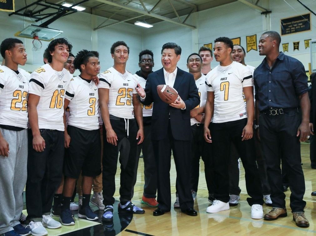 2015年9月23日，國家主席習(xí)近平參觀美國塔科馬市林肯中學(xué)。這是習(xí)近平在學(xué)校體育館，同上橄欖球訓(xùn)練課的學(xué)生們親切交談。新華社記者 蘭紅光 攝