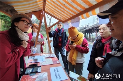 1月6日，“2024成都蒲江柑甜采摘節(jié)”上，記者見到了小萌（左一）和許多年輕人忙著做訪客接待、現(xiàn)場布置、票務核對、采摘服務等工作。人民網(wǎng)記者朱虹攝