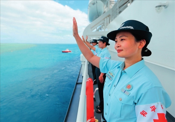 中國海軍“和平方舟”號醫(yī)院船結(jié)束訪問湯加時，任務(wù)官兵中的文職人員向歡送人群揮手告別（2023年8月4日攝）。徐巍攝/本刊