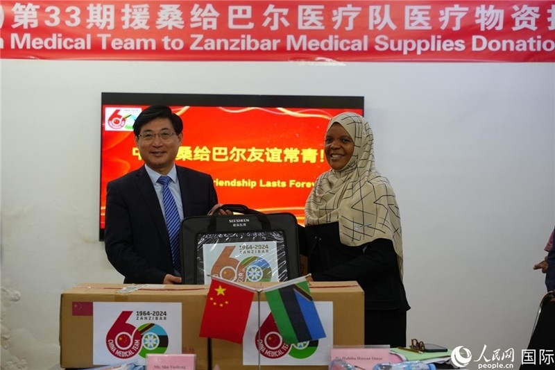 江蘇省蘇北人民醫(yī)院黨委書記束余聲捐贈物資與桑衛(wèi)生部首席秘書哈比巴。中國援桑醫(yī)療隊供圖