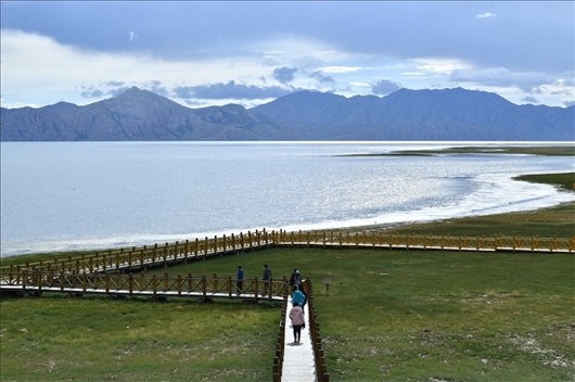 △ 游客行走在青?，敹嗫h冬格措納湖畔的木棧道上。