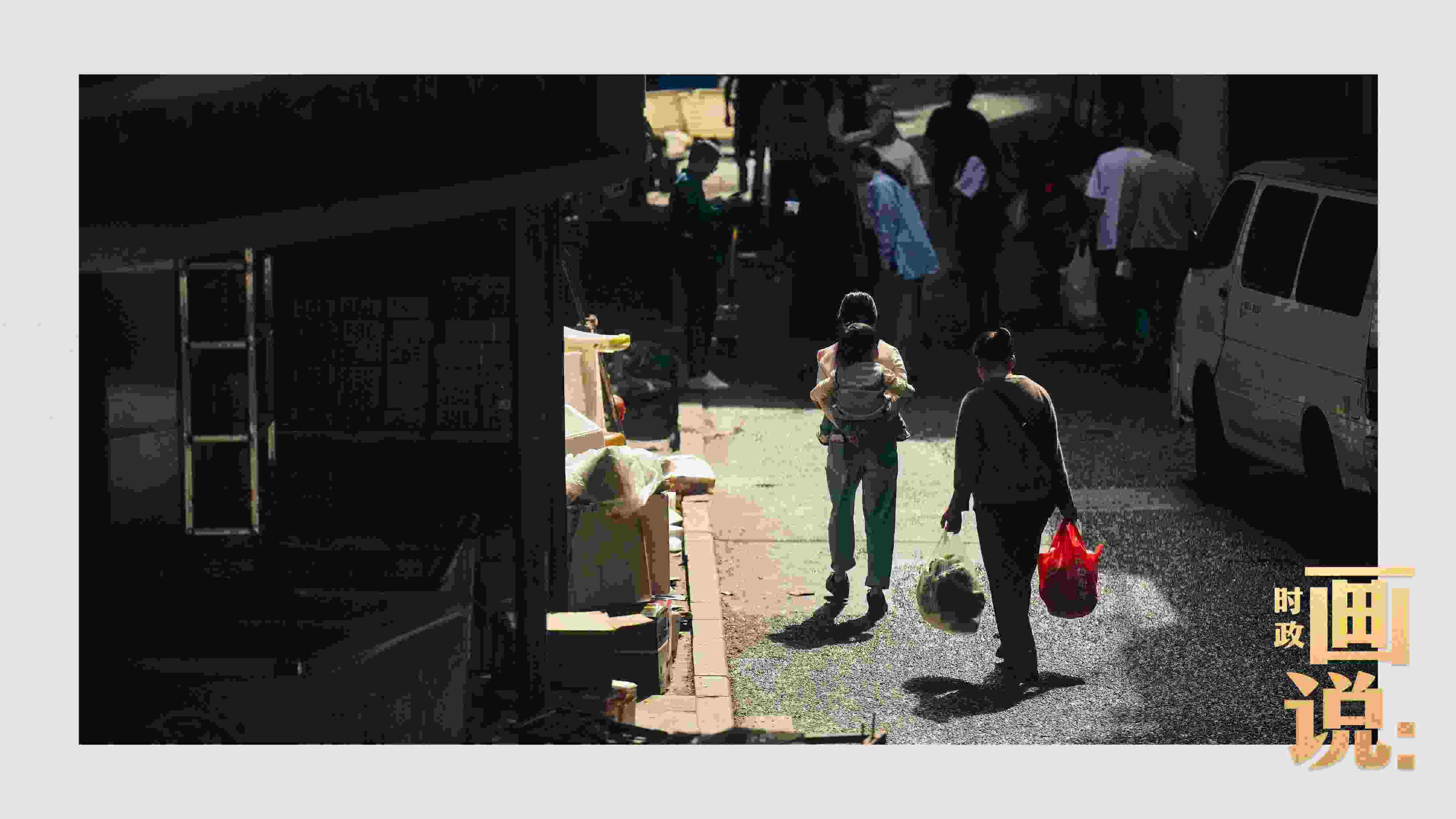 △老城區(qū)鱗次的樓宇間漏下一縷光，路人走過(guò)暖陽(yáng)。