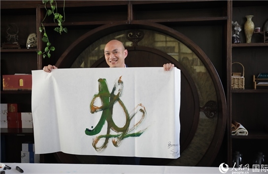 老撾駐華大使館三秘明君參加《五百筆·瀾湄合作》集體藝術(shù)創(chuàng)作。人民網(wǎng)王婧攝。