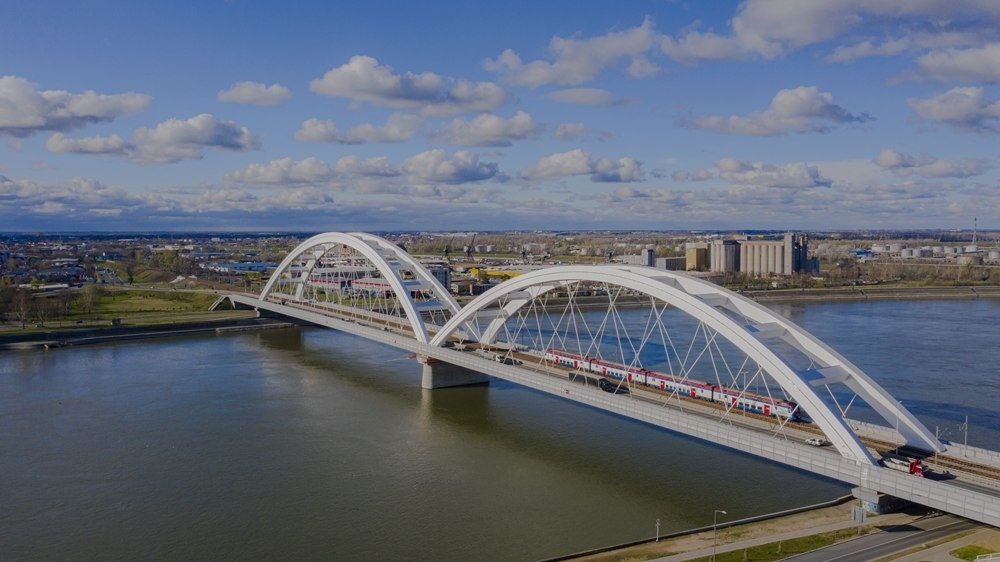 2024年3月12日，一列火車運(yùn)行在匈塞鐵路塞爾維亞境內(nèi)貝諾段諾維薩德多瑙河大橋上（無人機(jī)照片）。新華社發(fā)（任衛(wèi)云攝）