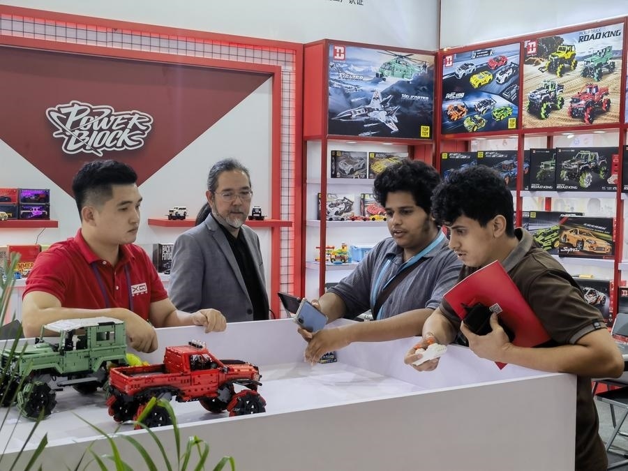 在第135屆廣交會第三期現(xiàn)場，采購商在廣東信宇科技股份有限公司展位選購、體驗積木遙控車產(chǎn)品（5月2日攝）。新華社記者 洪澤華 攝