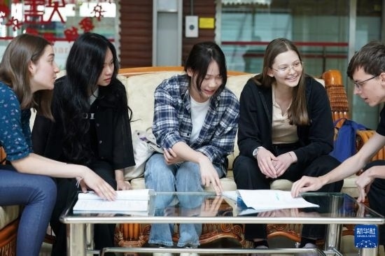 4月28日，宋智孝（右二）和胡靈月（左一）在北京首都師范大學(xué)校園內(nèi)與同學(xué)交流。新華社記者 彭子洋 攝