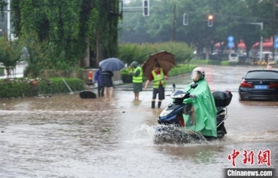 5月10日，廣西沿海遭遇強降雨。圖為欽州市民眾在積澇中出行。陸敏 攝