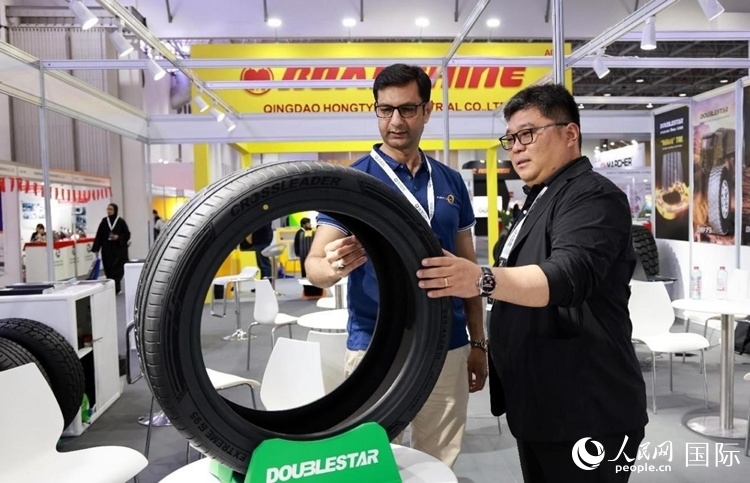 工作人員向客戶展示雙星電動汽車輪胎。和傳統(tǒng)汽車輪胎相比，電動汽車輪胎具有更高承載能力、更加靜音舒適、更好極速抓地、更低滾動阻力等特點。人民網(wǎng)記者 管克江攝