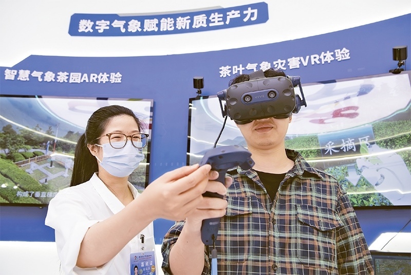 2024年5月23日，第七屆數(shù)字中國建設(shè)峰會現(xiàn)場體驗(yàn)區(qū)在福州海峽國際會展中心向?qū)I(yè)觀眾開放。本次現(xiàn)場體驗(yàn)區(qū)圍繞本屆峰會主題“釋放數(shù)據(jù)要素價(jià)值，發(fā)展新質(zhì)生產(chǎn)力”，設(shè)置“數(shù)字惠民”、“數(shù)字能力”、“數(shù)字基礎(chǔ)”、“數(shù)字生態(tài)”、“數(shù)字賦能”五大板塊。圖為一名觀眾（右）在數(shù)字氣象賦能新質(zhì)生產(chǎn)力展臺上進(jìn)行體驗(yàn)。 新華社記者 魏培全/攝