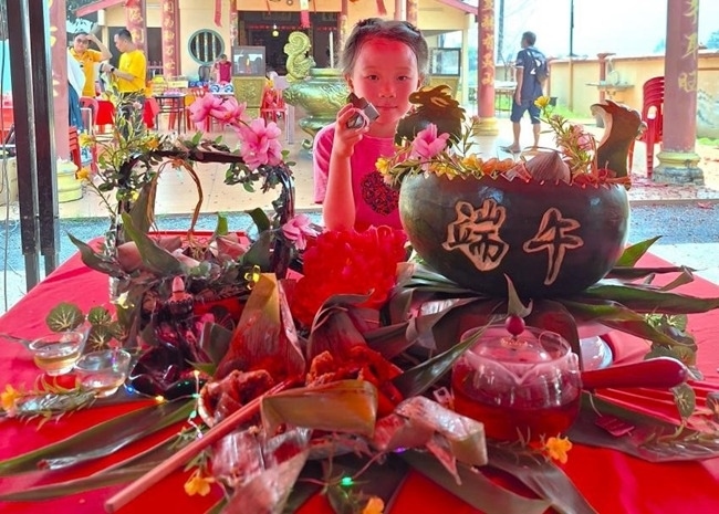 小朋友展示學(xué)裹粽子的成品照。組委會(huì)供圖