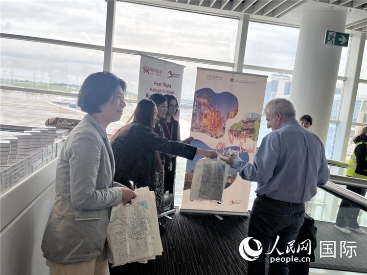 圖為工作人員向乘客發(fā)放復(fù)航首班禮物。 牛瑞飛攝