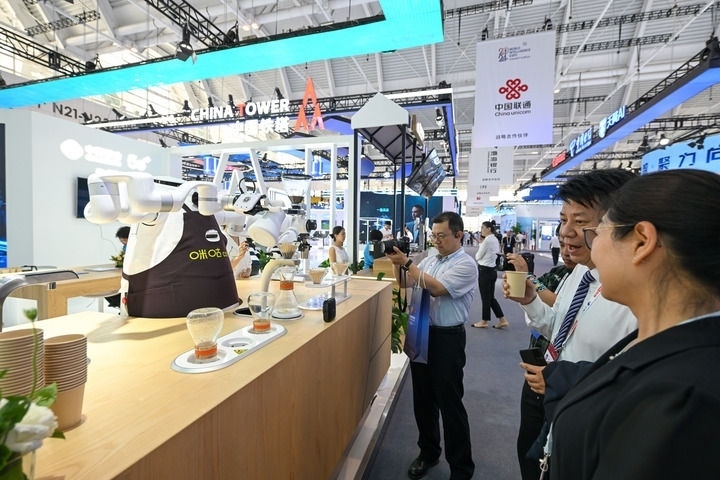 6月20日，與會者品嘗機器人沖調(diào)出的咖啡。新華社記者 孫凡越 攝