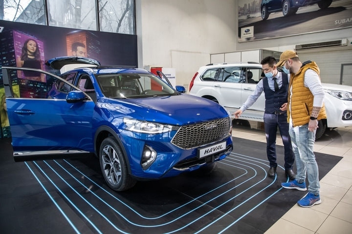 2021年4月1日，銷售人員在哈薩克斯坦阿拉木圖市經(jīng)銷商店向消費(fèi)者介紹哈弗汽車。新華社發(fā)（阿斯塔納汽車公司供圖）