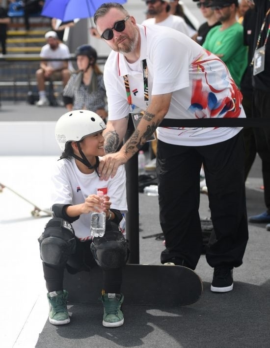 6月20日，鄭好好（左）在比賽間隙與教練互動，她在預賽中最佳成績?yōu)?2.60分。當日，巴黎奧運會資格系列賽布達佩斯站滑板女子碗池預賽在布達佩斯舉行。新華社記者 賀燦鈴 攝