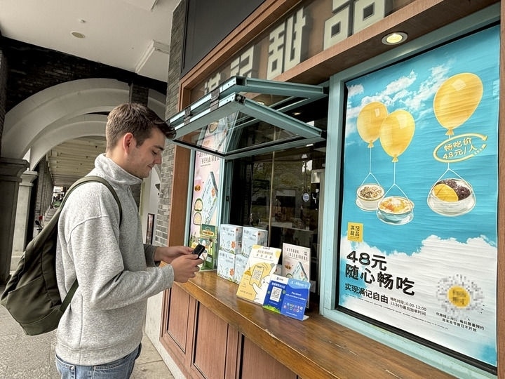 來自德國的留學(xué)生理查德在杭州西湖邊一家商鋪使用支付寶掃碼支付（2024年4月11日攝）。新華社發(fā)