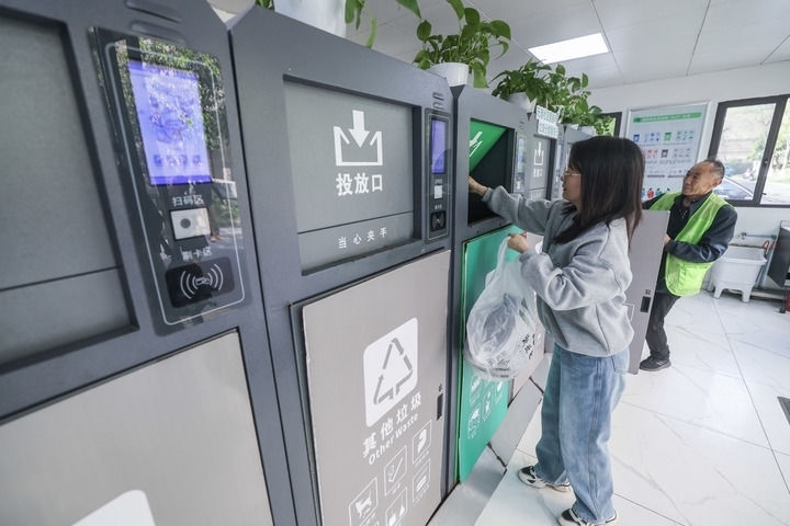 2024年4月10日，在浙江省湖州市吳興區(qū)飛英街道新華府小區(qū)內(nèi)，居民在垃圾分類智能系統(tǒng)的指導(dǎo)下進(jìn)行垃圾分類投放，居民的投放情況將實(shí)時匯總到智慧服務(wù)平臺，會有相應(yīng)的積分獎勵。新華社記者 徐昱 攝