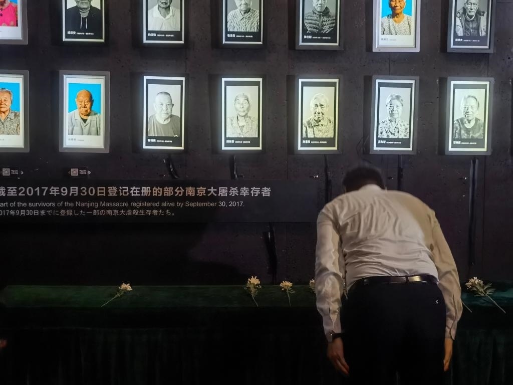 7月18日，人們向離世的南京大屠殺幸存者獻(xiàn)花、鞠躬。新華社記者邱冰清 攝