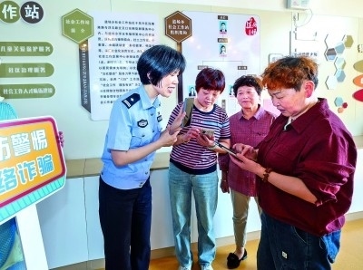 浙江湖州民警指導(dǎo)居民加入湖州“e企安”微信群，實(shí)時(shí)接收反詐信息。新華社發(fā)