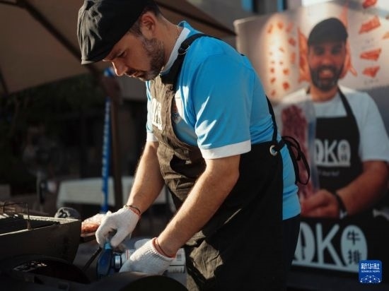 7月19日，在蕪湖古城，馬丁在當(dāng)天舉行的啤酒節(jié)上制作牛排。新華社發(fā)（繆雨晨 攝）