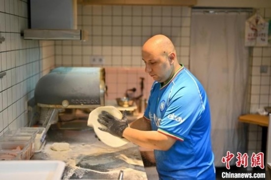 近日，韋榮耀在自家披薩小店內(nèi)忙活。俞靖 攝