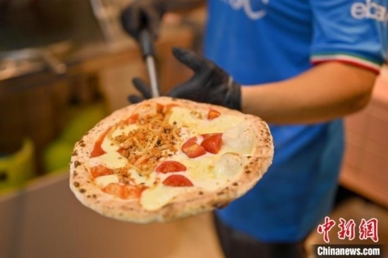 近日，韋榮耀展示他制作的“老友味”披薩。 俞靖 攝
