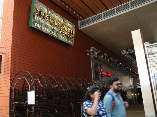 2023年5月29日，人們經(jīng)過美國紐約曼哈頓的“國債鐘”?！皣鴤姟笔且粋€大型計數(shù)器，它實時更新美國的公共債務(wù)總額，并顯示出每個美國家庭所要負(fù)擔(dān)的數(shù)額。 新華社記者劉亞南攝