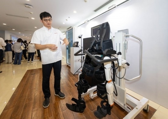 2024年5月24日，在位于上海市嘉定區(qū)的上海交通大學(xué)醫(yī)學(xué)院附屬瑞金醫(yī)院腫瘤質(zhì)子中心，工作人員介紹由瑞金醫(yī)院醫(yī)生和醫(yī)療公司共同研發(fā)的用于恢復(fù)患者下肢的醫(yī)療機(jī)器人。新華社記者 王翔 攝
