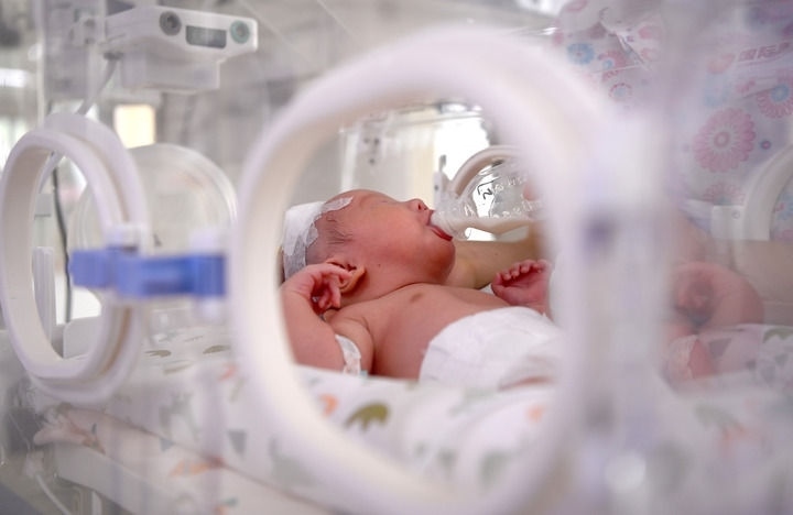 2024年6月1日，在西安國(guó)際醫(yī)學(xué)中心醫(yī)院新生兒科病房，護(hù)士為新生兒喂奶。 新華社記者 劉瀟 攝