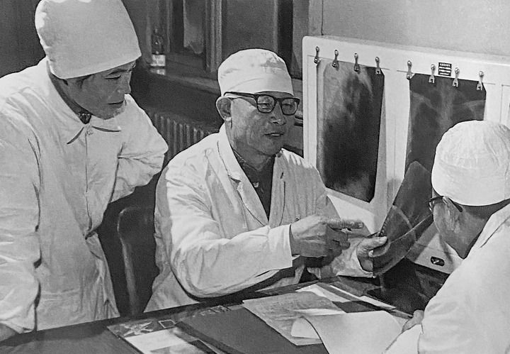 1980年1月16日，中日友好醫(yī)院首任院長(zhǎng)辛育齡（中）在內(nèi)蒙古結(jié)核病院與胸外科醫(yī)師討論病例（翻拍照片）。 新華社發(fā)