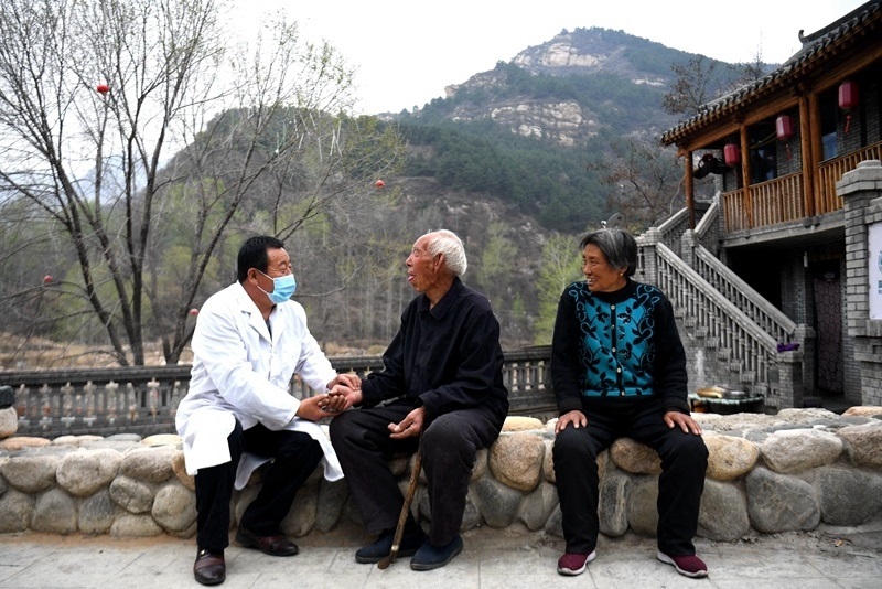 2020年4月15日，在河北阜平縣龍泉關(guān)鎮(zhèn)駱駝灣村，村醫(yī)霍建國為村民把脈。