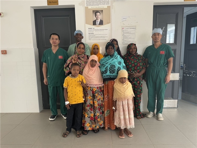 李廣（右一）和王林醫(yī)生與部分患者合影。中國(guó)援桑醫(yī)療隊(duì)供圖