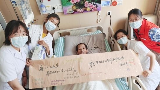 7月26日，海淀醫(yī)院安寧療護(hù)科醫(yī)護(hù)團(tuán)隊(duì)為朱銳送來一條寫滿祝福的橫幅。（受訪者供圖）