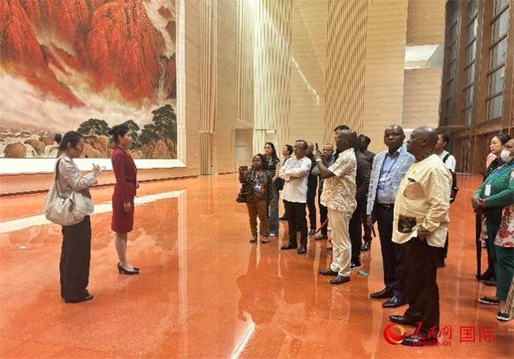 代表團(tuán)在入口處聽取講解。人民網(wǎng) 曹欣悅攝