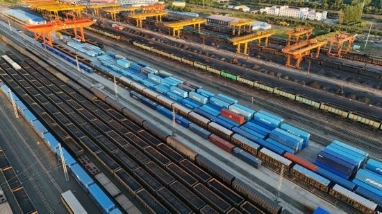 這是2024年8月14日在黑龍江綏芬河鐵路口岸集裝箱換裝場(chǎng)拍攝的集裝箱換裝作業(yè)現(xiàn)場(chǎng)（無(wú)人機(jī)照片）。今年前七個(gè)月，綏芬河鐵路口岸開(kāi)行中歐班列573列，運(yùn)量達(dá)55246標(biāo)箱，同比分別增長(zhǎng)23%和18%，班列數(shù)量持續(xù)保持高位運(yùn)行。