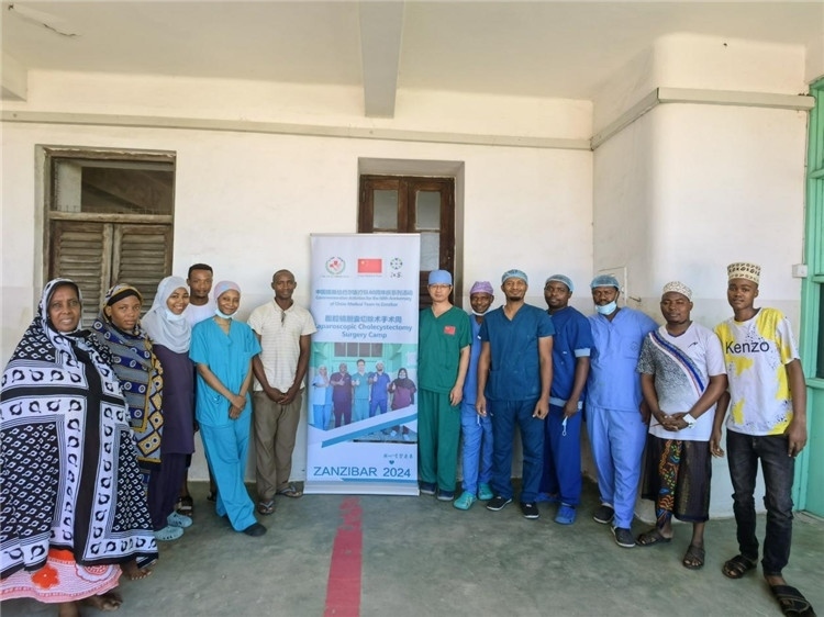 隊長蔣國慶（右七）和手術醫(yī)生、部分患者合影。中國援桑醫(yī)療隊供圖