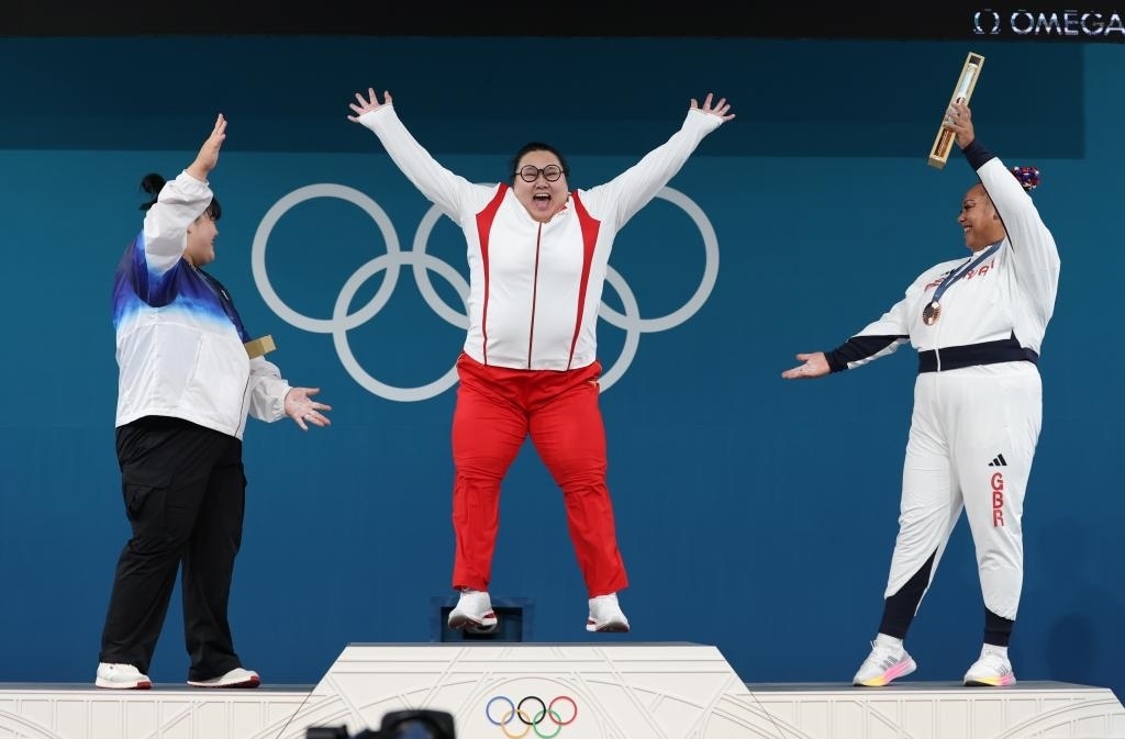 中國(guó)選手李雯雯（中）在巴黎奧運(yùn)會(huì)舉重女子81公斤以上級(jí)頒獎(jiǎng)儀式中登上領(lǐng)獎(jiǎng)臺(tái)（2024年8月11日攝）。新華社記者 楊磊 攝