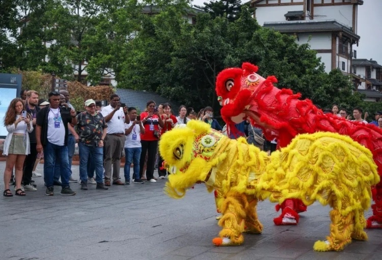 2024“一帶一路”媒體合作論壇聯(lián)合采訪調(diào)研行成員在樂山蘇稽古鎮(zhèn)觀看非遺舞獅表演。本報記者 伊霄攝