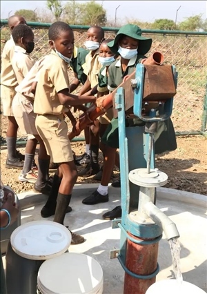 △2021年11月，在津巴布韋南馬塔貝萊蘭省省會關(guān)達(dá)的塞農(nóng)多小學(xué)，學(xué)生從中國援建水井里打水。