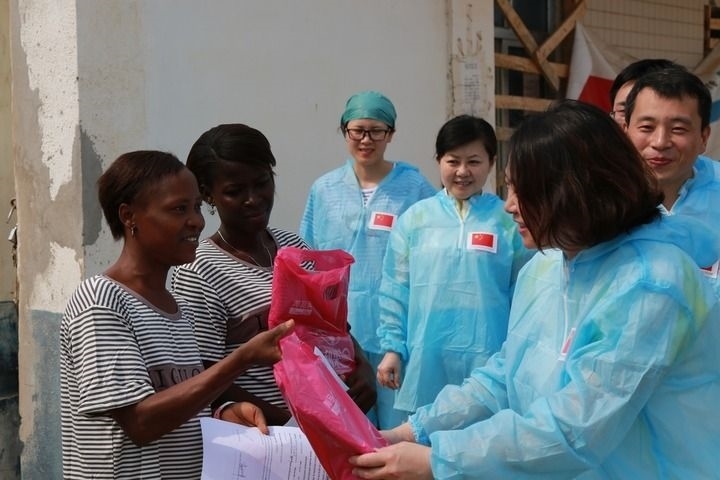 2015年4月4日，在位于塞拉利昂首都弗里敦市郊的中塞友好醫(yī)院埃博拉診療中心，中國第四批援塞醫(yī)療隊(duì)副隊(duì)長邵蔚（右前）向被治愈的埃博拉出血熱患者贈送禮物。新華社發(fā)（祖榮強(qiáng) 攝）