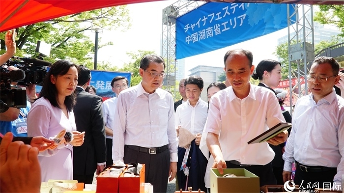 湖南展位工作人員向中國駐日本大使吳江浩介紹特色文創(chuàng)產(chǎn)品。人民網(wǎng) 蔣曉辰攝