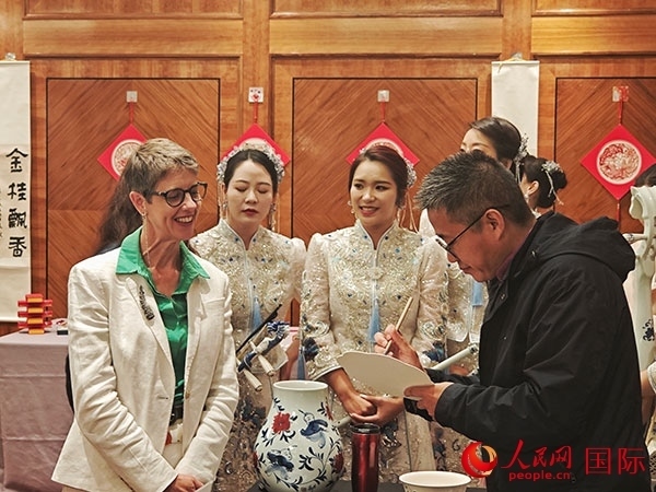 現(xiàn)場的非遺傳承人為英國觀眾展示畫技。人民網(wǎng)記者 邢雪攝