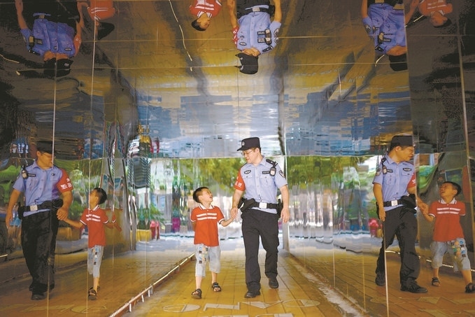 ?7月16日，重慶市公安局江北區(qū)分局一名民警在巡邏途中遇到一個獨自玩耍的小男孩，民警將其送回家。王洪平攝