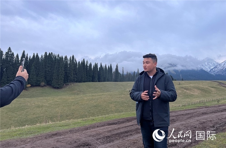 在庫爾德寧，吾買爾江被雪山美景震撼，即興錄制了短視頻作品。人民網(wǎng)記者曾書柔攝