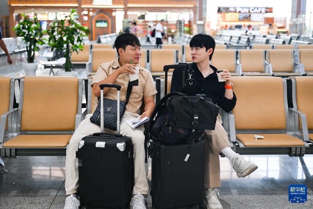 10月12日，在老撾萬(wàn)象中老鐵路萬(wàn)象站候車(chē)廳，兩名乘客在等候列車(chē)。新華社記者 程一恒 攝