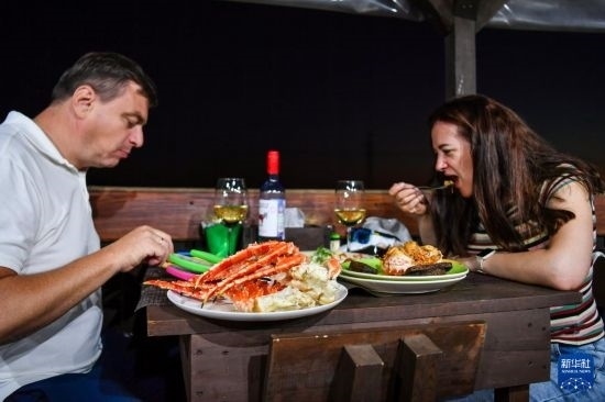 9月2日，食客們在俄羅斯符拉迪沃斯托克的一家餐館品嘗帝王蟹。新華社記者 曹陽 攝