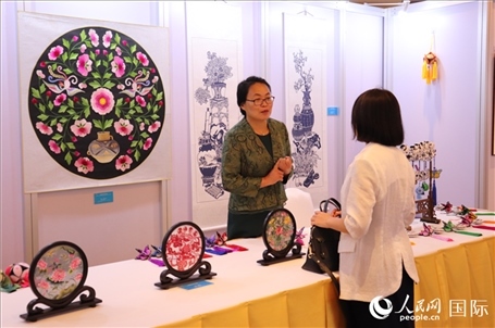 青海非遺文化傳承人向嘉賓介紹展品。人民網(wǎng)實(shí)習(xí)生姚欣可攝