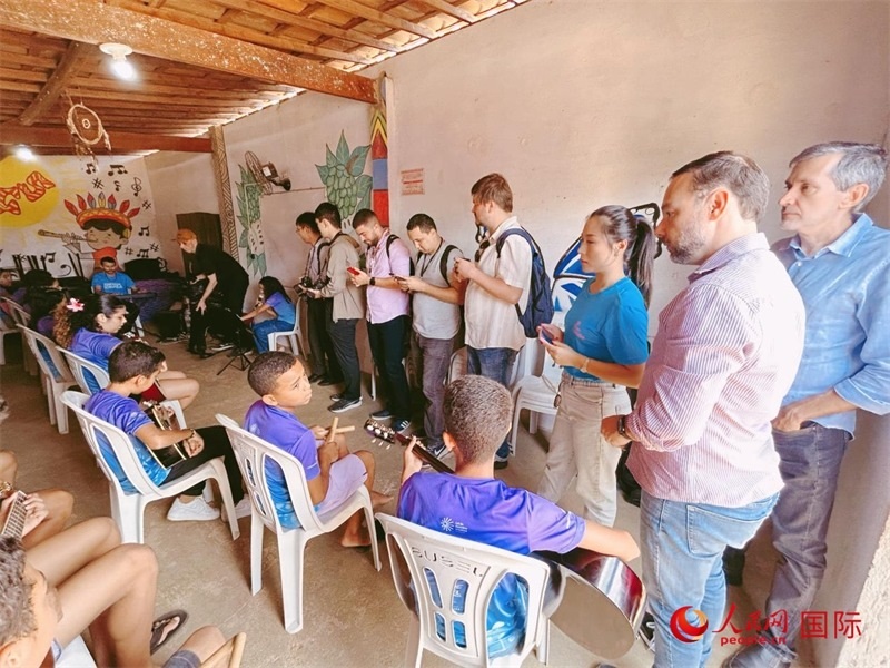  受益于中國企業(yè)的“青少年成長”項目，700多名當?shù)厍嗌倌甑囊魳泛妥闱驂粝氩迳狭顺岚?。圖為聯(lián)合采訪團正在采訪參加音樂培訓的孩子們。 人民網(wǎng)記者 陳一鳴攝