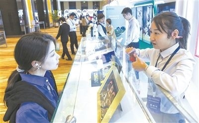 在北京麗澤商務(wù)區(qū)，工作人員（右一）介紹數(shù)字人民幣SIM卡硬錢包。新京報記者 陶冉攝